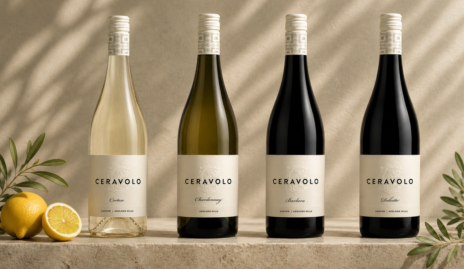 Ceravolo wine bottles on a stone surface with lemon slices and olive leaves.